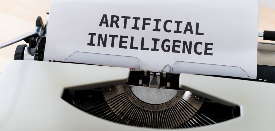 sheet of paper in a typewriter that has the words "artificial intelligence" typed on it